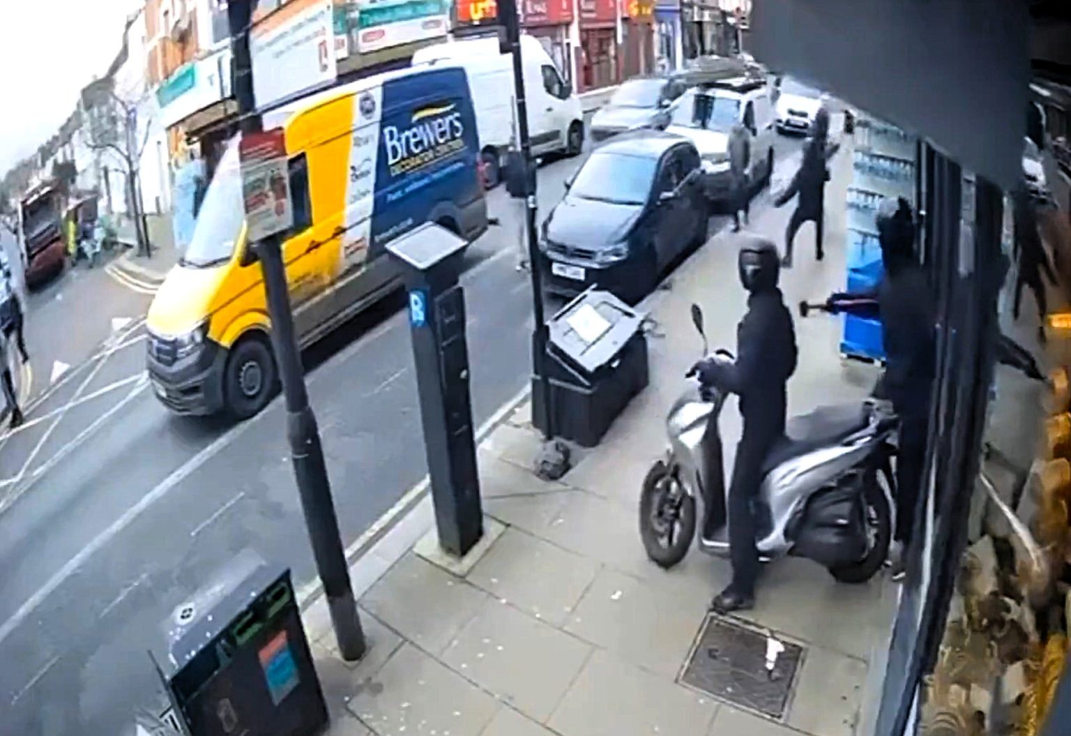 Machete-wielding thugs on mopeds storm jewellery shop in broad daylight in North London - brave bystander tries to fight back with a broom as masked gang smashes display cases.