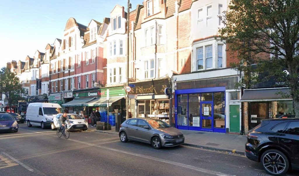 Machete-wielding thugs on mopeds storm jewellery shop in broad daylight in North London - brave bystander tries to fight back with a broom as masked gang smashes display cases.