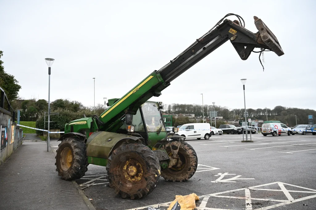 Ram raid gang uses stolen John Deere telehandler to smash into Co-op and steal cash point in Plympton, Devon. Sophisticated four-person gang linked to burglaries.