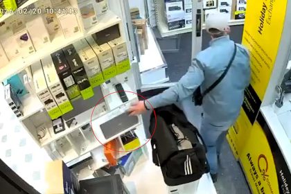 Brazen thief caught on CCTV swiping laptop in seconds while distracting staff by trying to sell his old one at Peterborough store - then casually walks out saying thank you.
