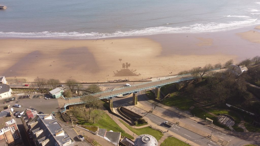 Artist Fred Brown recreates Banksy's iconic Kids on Guns artwork on Scarborough beach using just a rake - a powerful tribute amid global conflict that stunned visitors.