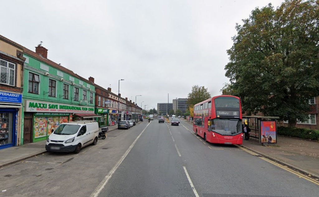 Shocking footage shows a furious driver kicking a bike and grabbing a biker during a heated road rage clash on Harrow Road in Wembley - as stunned motorists watched in horror.