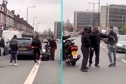 Shocking footage shows a furious driver kicking a bike and grabbing a biker during a heated road rage clash on Harrow Road in Wembley - as stunned motorists watched in horror.