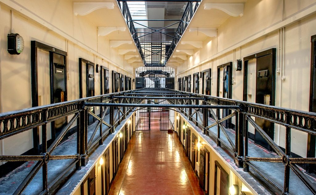 Spooky CCTV footage shows books flying off a shelf in an empty shop at a 150-year-old former jail where 15 prisoners are still buried within its walls.
