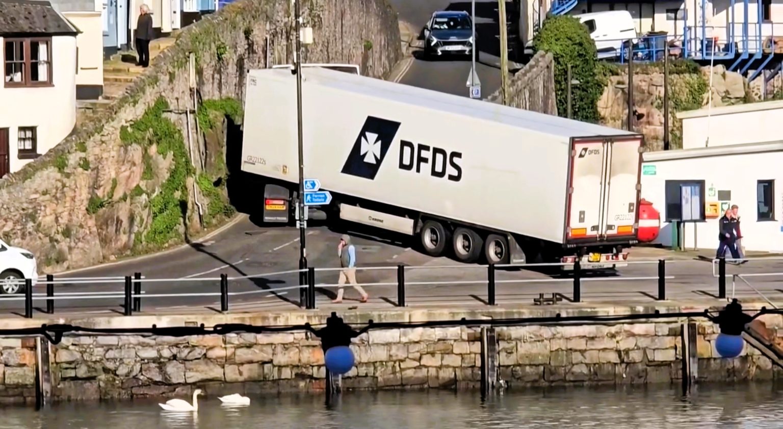 Huge HGV gets stuck in a tight spot after its driver takes a wrong turn near Brixham harbour in Devon - with the cab perilously close to a stone wall during a tricky reversal.