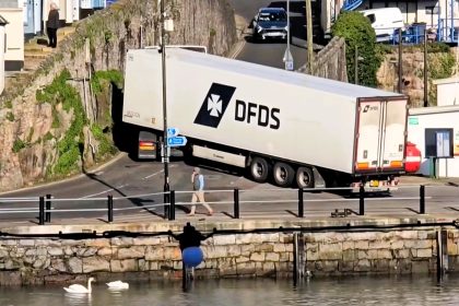 Huge HGV gets stuck in a tight spot after its driver takes a wrong turn near Brixham harbour in Devon - with the cab perilously close to a stone wall during a tricky reversal.