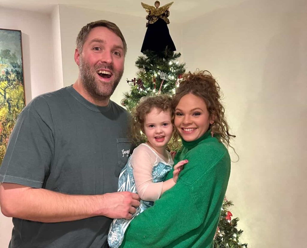 A woman woke up with tingling toes and was paralysed within days by a rare condition - now she has run a marathon and crossed the finish line with her daughter in her arms.