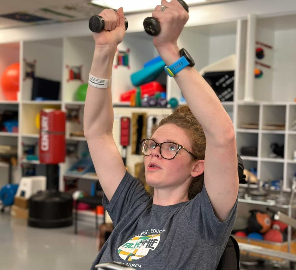 A woman woke up with tingling toes and was paralysed within days by a rare condition - now she has run a marathon and crossed the finish line with her daughter in her arms.