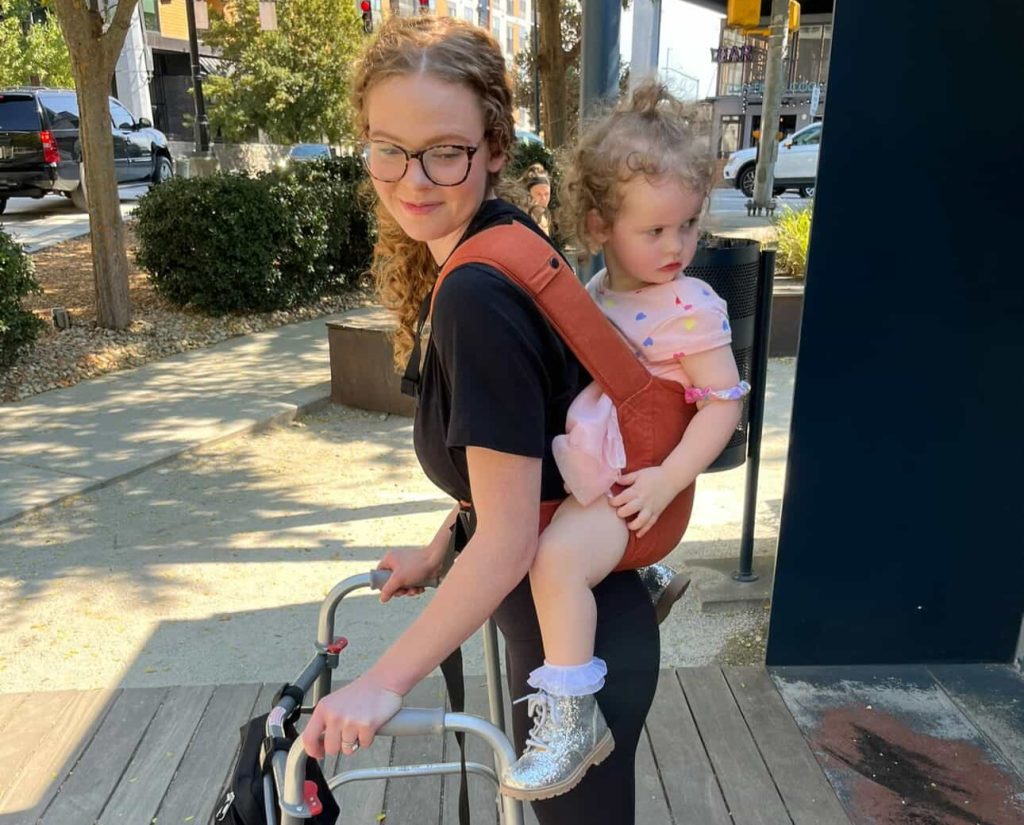 A woman woke up with tingling toes and was paralysed within days by a rare condition - now she has run a marathon and crossed the finish line with her daughter in her arms.