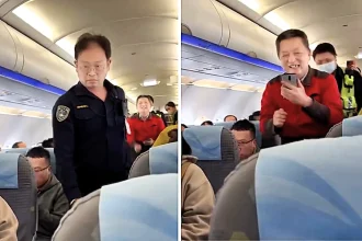 Passenger thrown off plane after refusing to sit in his allocated seat and shouting at cabin crew - even smiling and waving as police led him through the cabin in Taiwan.