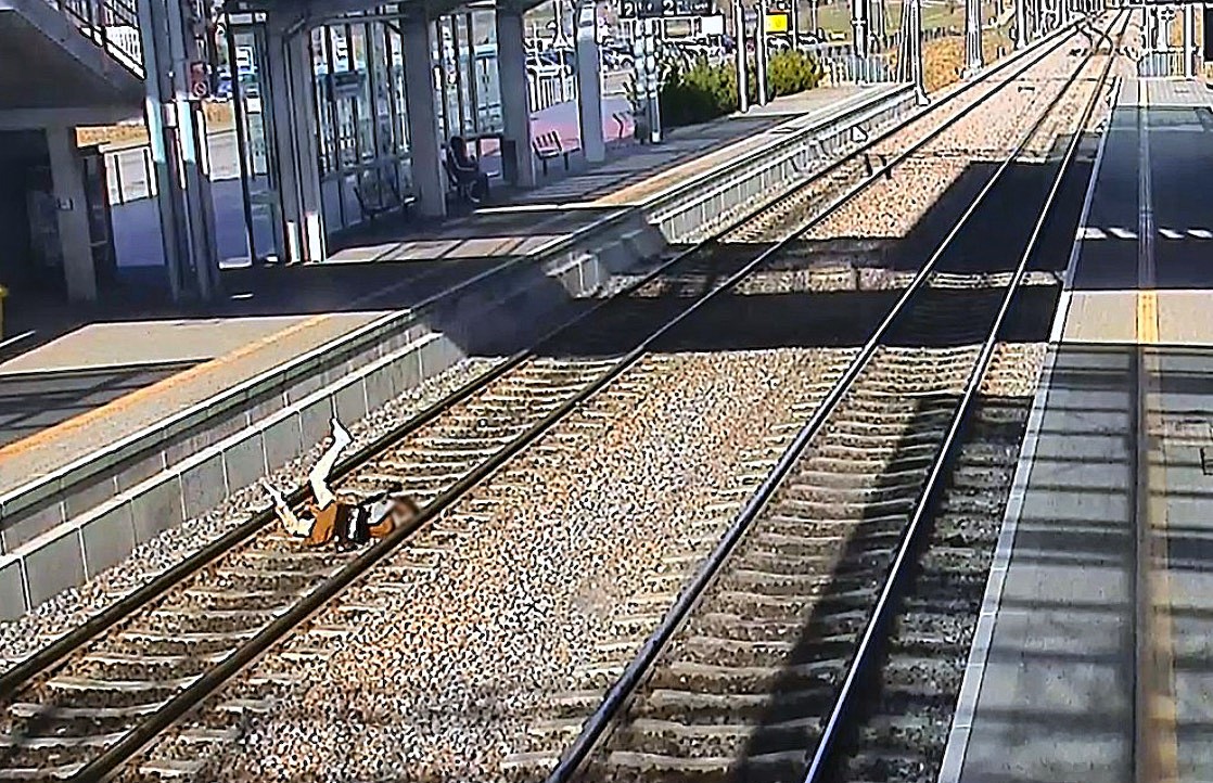 A woman fell face-first onto train tracks in Poland after being distracted on her phone, prompting the railway operator to release footage as a stark safety warning.