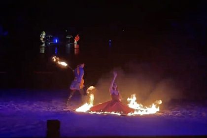 A dancer was engulfed in flames during a fire show at a zoo before leaping into a river to save herself, escaping serious injury in the dramatic incident.