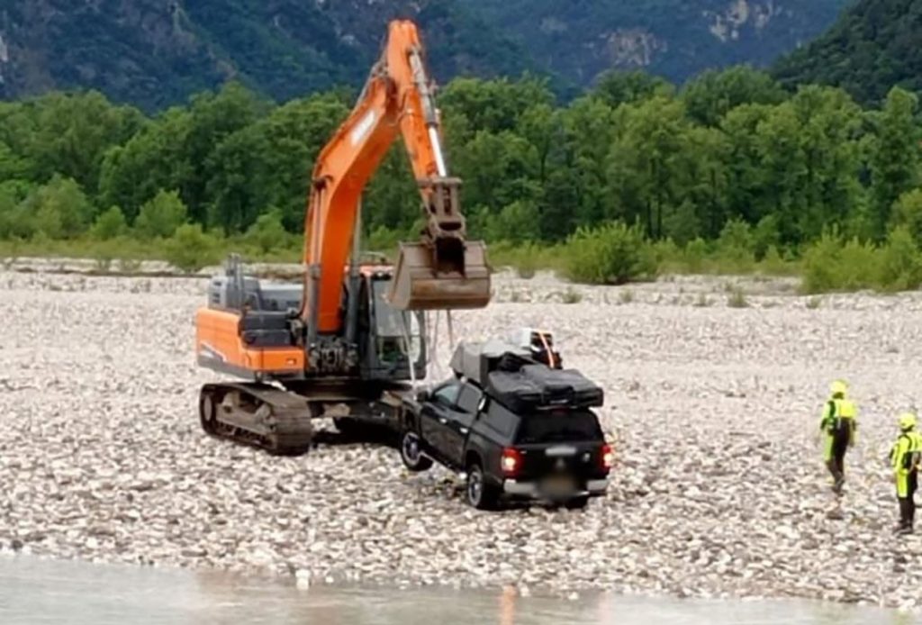 Two tourists and their dogs had to be rescued by helicopter and river teams after driving their pickup truck into a fast-flowing Italian river - and getting stranded in the middle.
