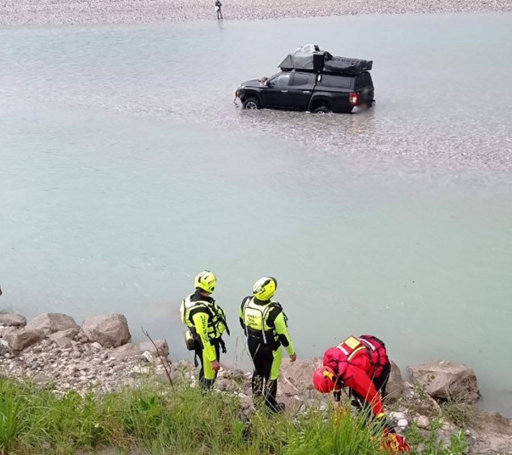 Two tourists and their dogs had to be rescued by helicopter and river teams after driving their pickup truck into a fast-flowing Italian river - and getting stranded in the middle.