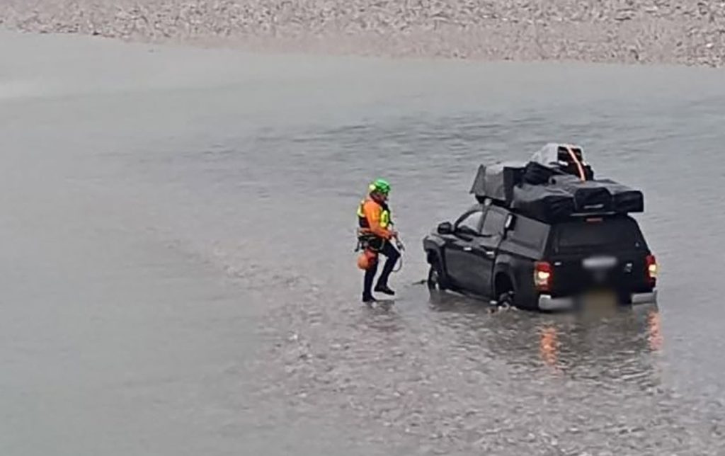 Two tourists and their dogs had to be rescued by helicopter and river teams after driving their pickup truck into a fast-flowing Italian river - and getting stranded in the middle.