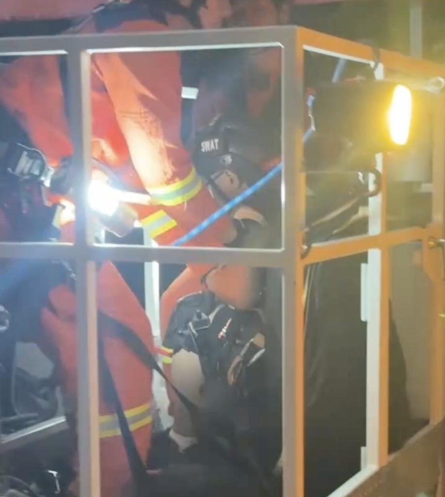 A paraglider was left dangling from a 197ft construction crane after his lines became tangled in the structure - firefighters spent hours cutting him free in a night-time rescue operation.
