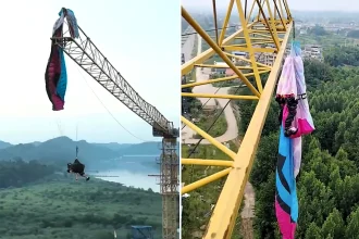 A paraglider was left dangling from a 197ft construction crane after his lines became tangled in the structure - firefighters spent hours cutting him free in a night-time rescue operation.
