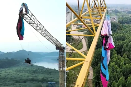 A paraglider was left dangling from a 197ft construction crane after his lines became tangled in the structure - firefighters spent hours cutting him free in a night-time rescue operation.