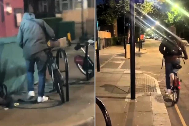 A woman on Portobello Road repeatedly called a masked man a "criminal" and told him to "get a job" as he sawed through a bike lock - and he left without taking the bicycle.