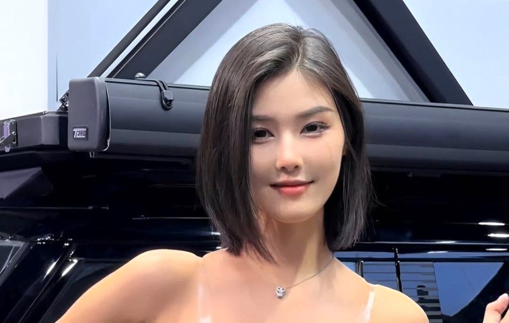 A knifeman burst from a crowd and allegedly lunged at a car model influencer during a live stream at a Chinese motor show - security pinned him down as she fled uninjured.