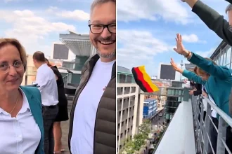 AfD politicians were stunned when police arrived at their Bundestag balcony for waving the German flag at a protest - one officer reportedly looked embarrassed himself.