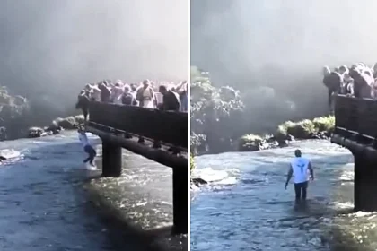 A reckless tourist clambered over a barrier and lowered himself into the river at Iguazu Falls to retrieve a dropped phone, just yards from the deadly waterfall's edge.