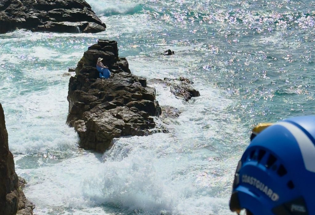 Rescuers rushed to a woman stranded on a tiny rock surrounded by sea in Cornwall after locals spotted her sitting in a chair - crews had to wait hours for the tide to drop to reach her.