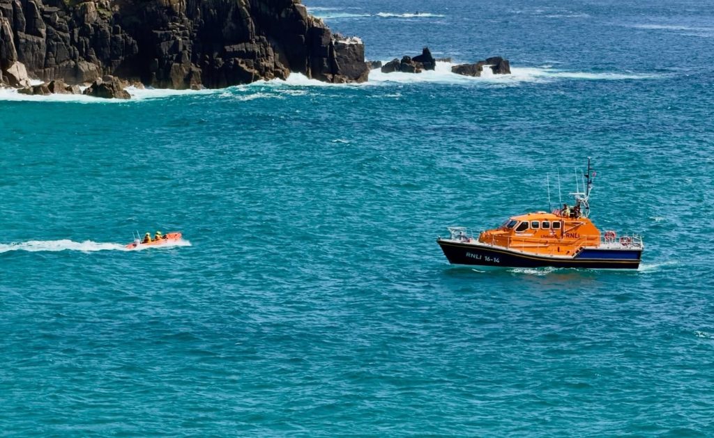 Rescuers rushed to a woman stranded on a tiny rock surrounded by sea in Cornwall after locals spotted her sitting in a chair - crews had to wait hours for the tide to drop to reach her.