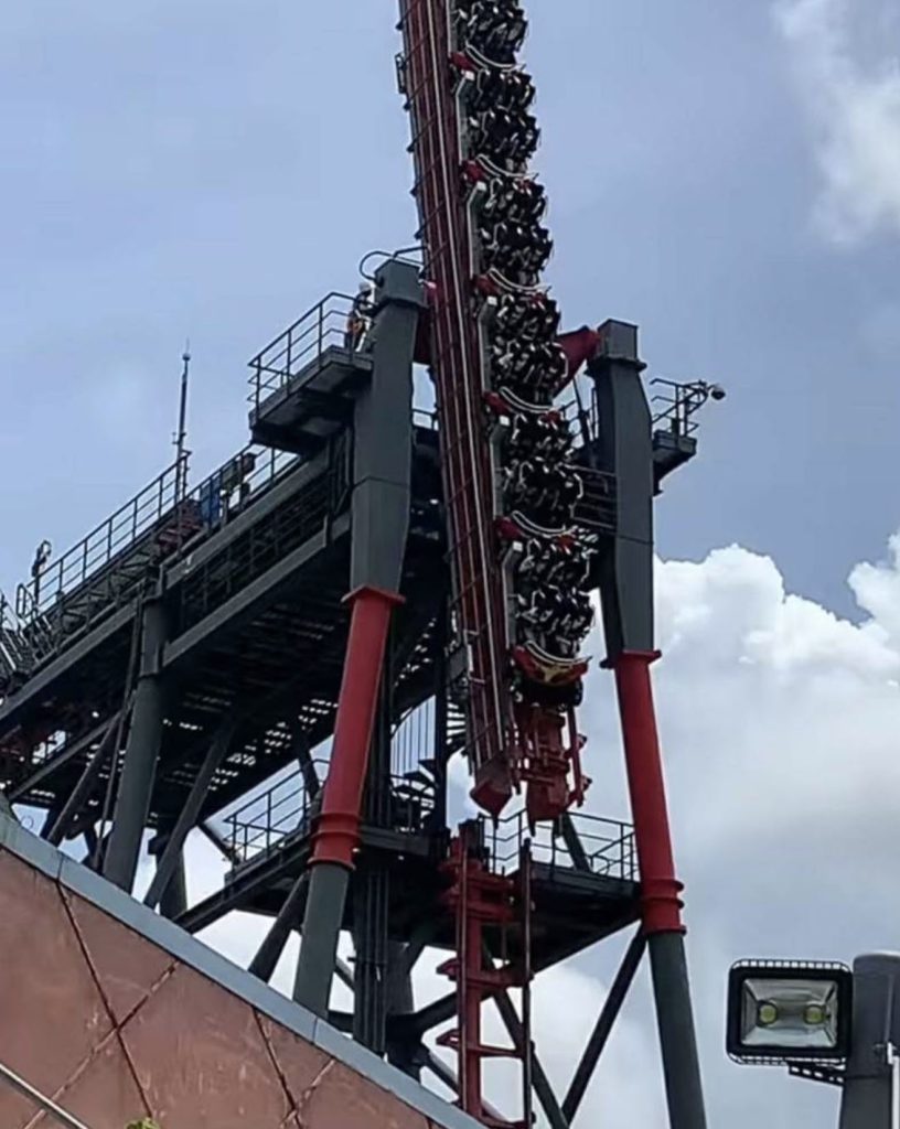 Twenty riders including schoolchildren were left dangling face-down at a near-vertical angle on a Taiwan rollercoaster for eight minutes as torrential rain lashed down.