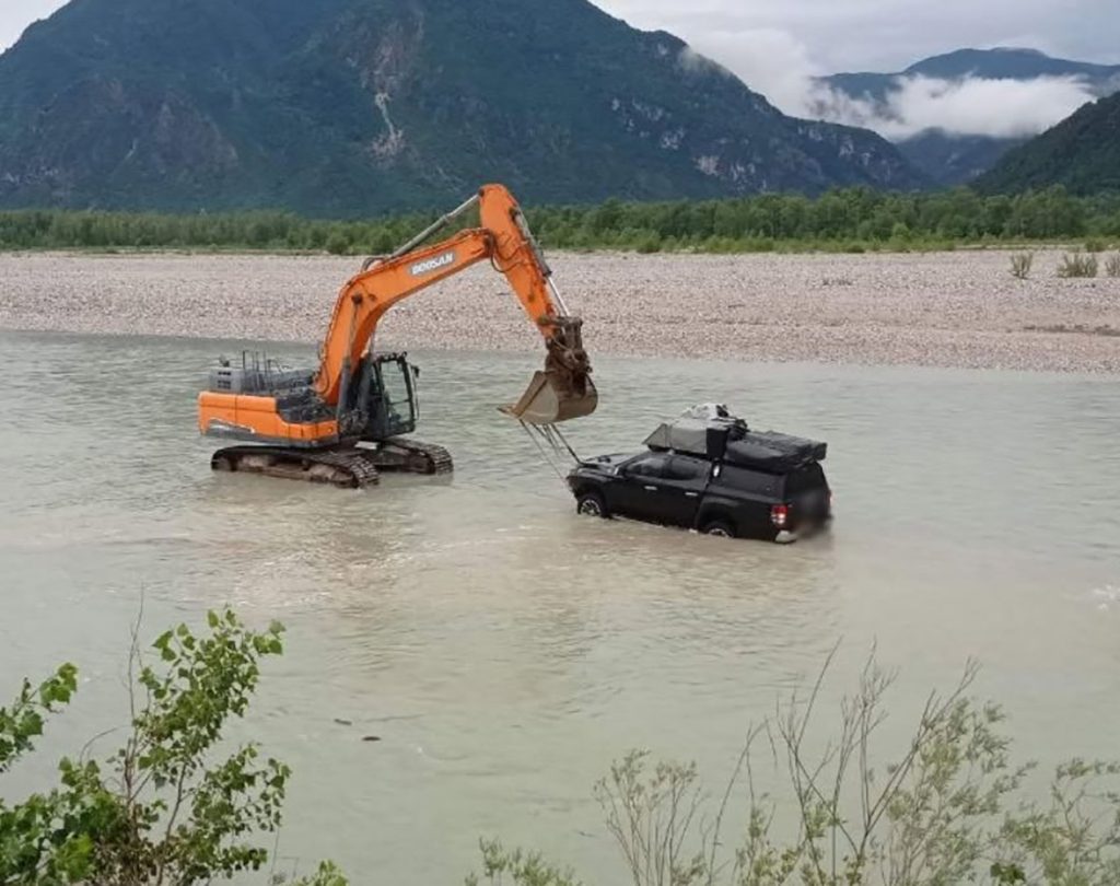 Two tourists and their dogs had to be rescued by helicopter and river teams after driving their pickup truck into a fast-flowing Italian river - and getting stranded in the middle.