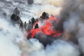 Britain's record-breaking June heatwave sparked a huge wildfire on Derbyshire moorland, sending a massive plume of smoke billowing for miles as crews and a helicopter battled the blaze.