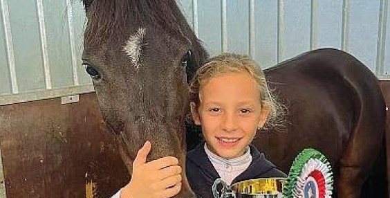 An 11-year-old girl has died after her hair became trapped in a swimming pool's suction outlet while on holiday in Italy - a manager cut it to free her.