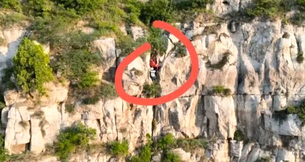 Tourist Ren Mou survives 180ft cliff plunge in China after getting wedged in a crevice, sparking a five-hour overnight rescue mission to save her.