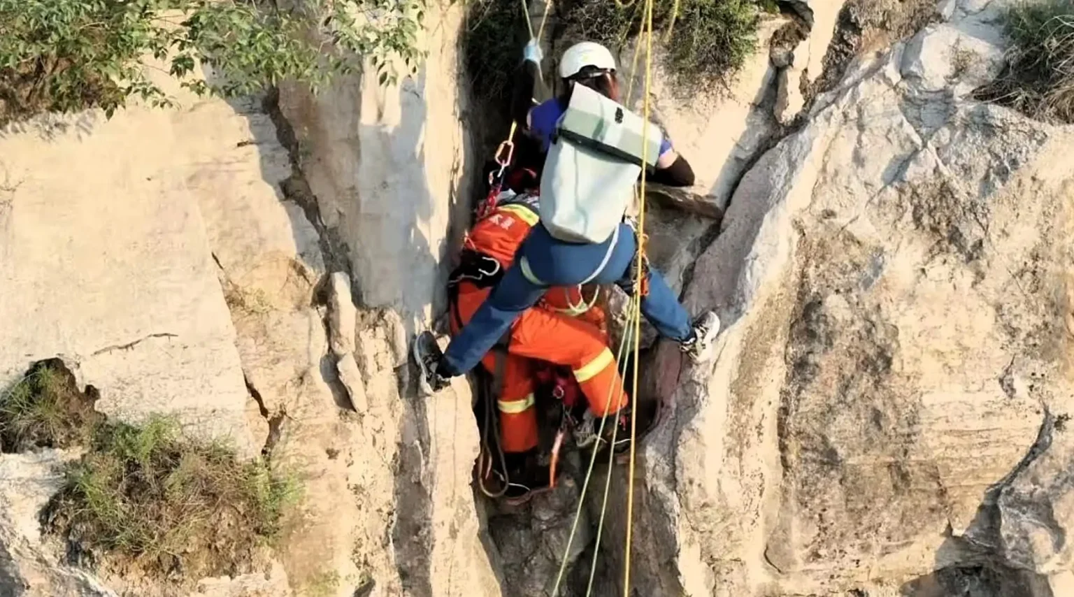 Tourist Ren Mou survives 180ft cliff plunge in China after getting wedged in a crevice, sparking a five-hour overnight rescue mission to save her.