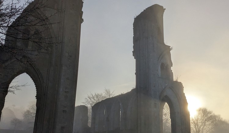 An abbot's kneecap pinched from an opened tomb by an 11-year-old boy on a 1956 school trip has been returned to Glastonbury Abbey over 70 years later.