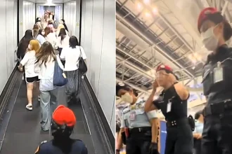 Airport officials have apologised after a security guard was filmed apparently making a racist gesture to Chinese tourists during a chaotic boarding row in Bangkok.