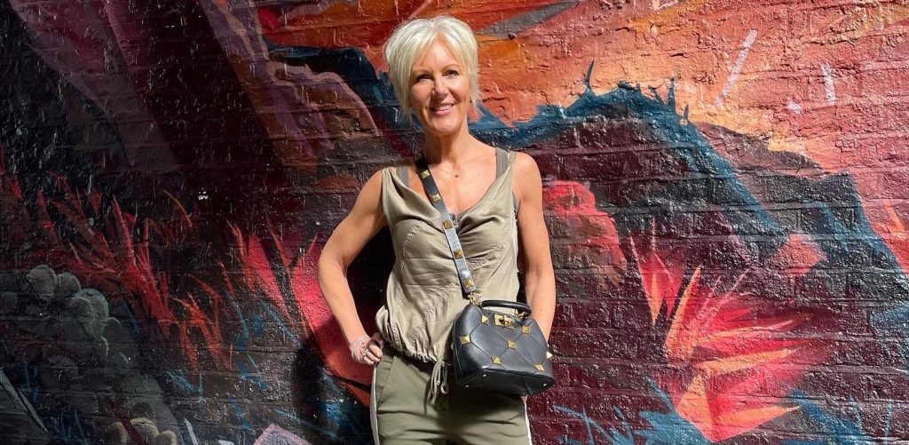 A fashion boss branded an inappropriate granny for refusing to cover up has welcomed her first grandchild - but says she won't be swapping corsets for cardigans.