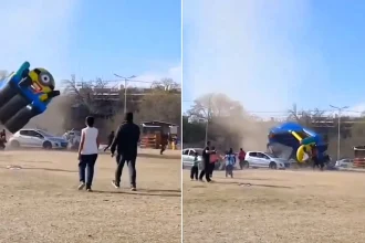 Two children aged six and seven were hospitalised with head injuries after a Minions bouncy castle was blown into the air at a Children's Day event in Argentina.