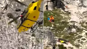 Shocking footage shows a rescue doctor stumbling and tumbling down a rocky mountainside alongside her stretcher - while trying to save a stranded climber.
