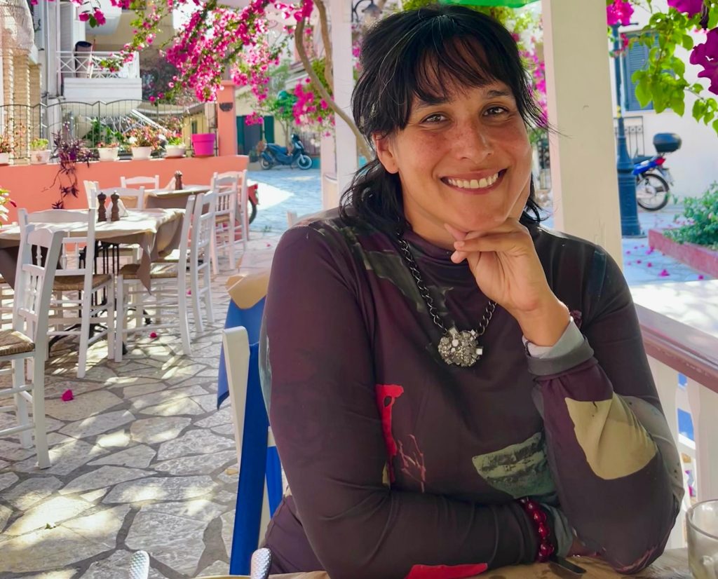 A filmmaker has died after being hit by a car while getting her beloved dog out of danger in the road - the driver allegedly fled the scene.