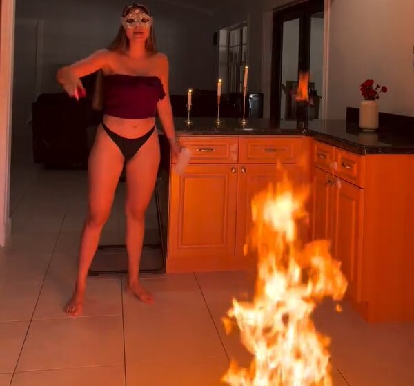 A mum has been arrested after videos allegedly showed her pouring melted candle wax onto her young daughters and setting fire to clothing inside their home.