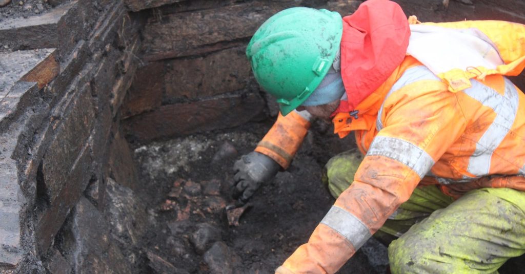 Archaeologists have unearthed a mysterious 2,000-year-old Iron Age pit holding a woman's skeleton - with one expert joking it could have been an ancient hot tub.