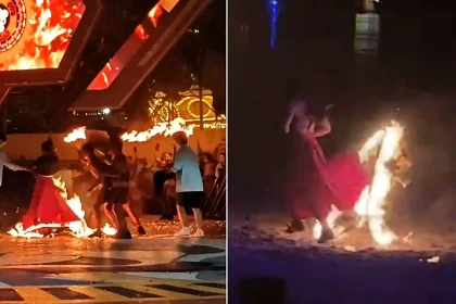 A performer's red dress erupted in flames mid-act during a special effects show as horrified colleagues scrambled to smother the blaze with a mat at a Chinese amusement park.
