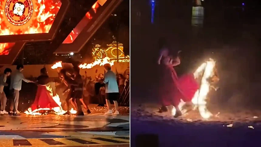 A performer's red dress erupted in flames mid-act during a special effects show as horrified colleagues scrambled to smother the blaze with a mat at a Chinese amusement park.