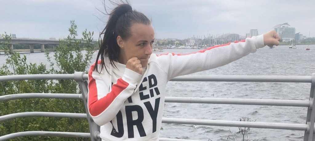 A champion boxer has flown home to the UK after suffering a bleed on the brain during sparring - with fans raising more than £97,000 to bring her back.