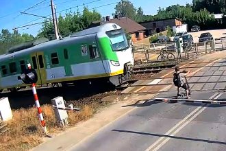 An e-scooter rider cheated death by inches after ignoring lowered barriers at a level crossing and riding straight into the path of a speeding train in Poland.