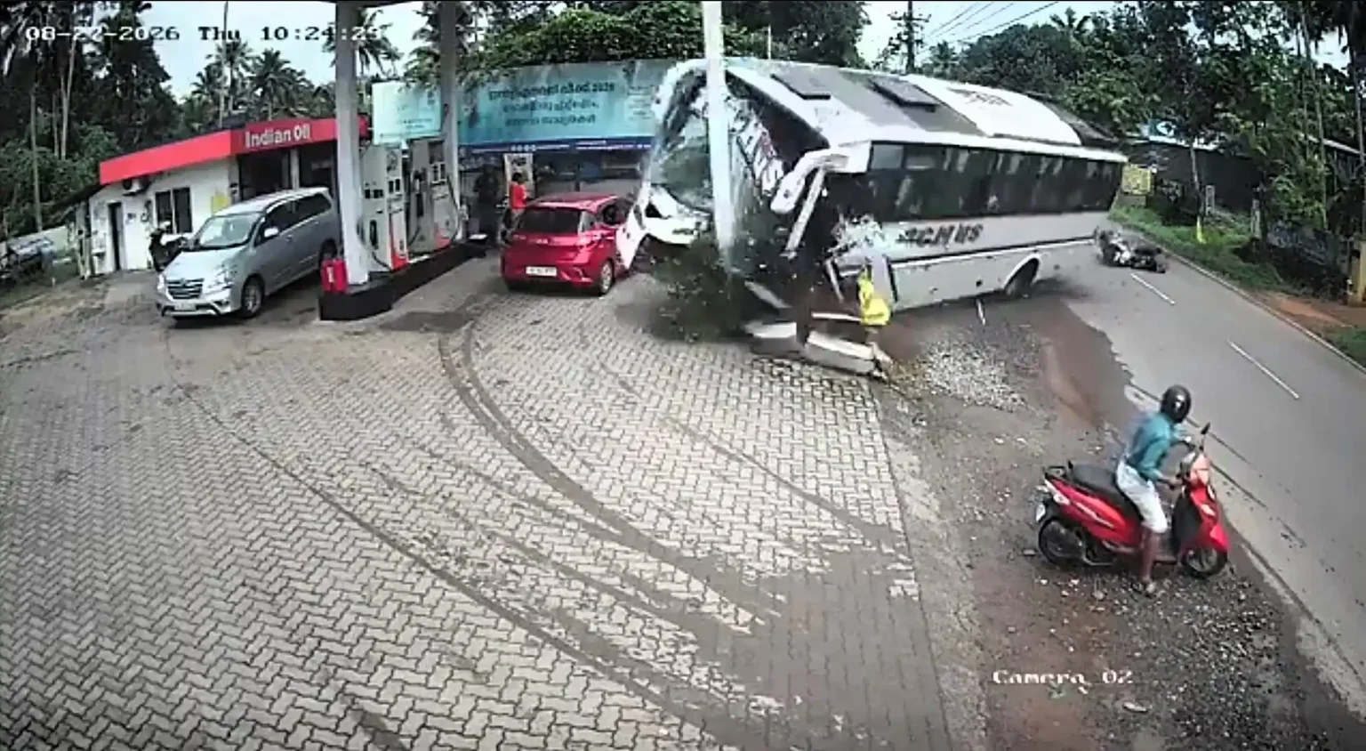 Dramatic CCTV shows a wedding party's bus swerving to avoid a scooter before rolling onto its side at a petrol station - stopping just short of the fuel pumps.