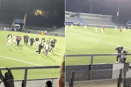 Furious fans vaulted the fence to attack their own players moments before the final whistle - forcing the 20-year-old goalkeeper to sprint out and defend them.