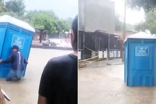 An unlucky bloke mid-poo was swept away when a flash flood sent his portable toilet careering down the street - with shouts for help heard coming from inside.