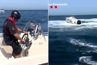 Dramatic footage shows a police officer leaping onto a runaway boat circling out of control off the Spanish coast - after its skipper fell into the sea.